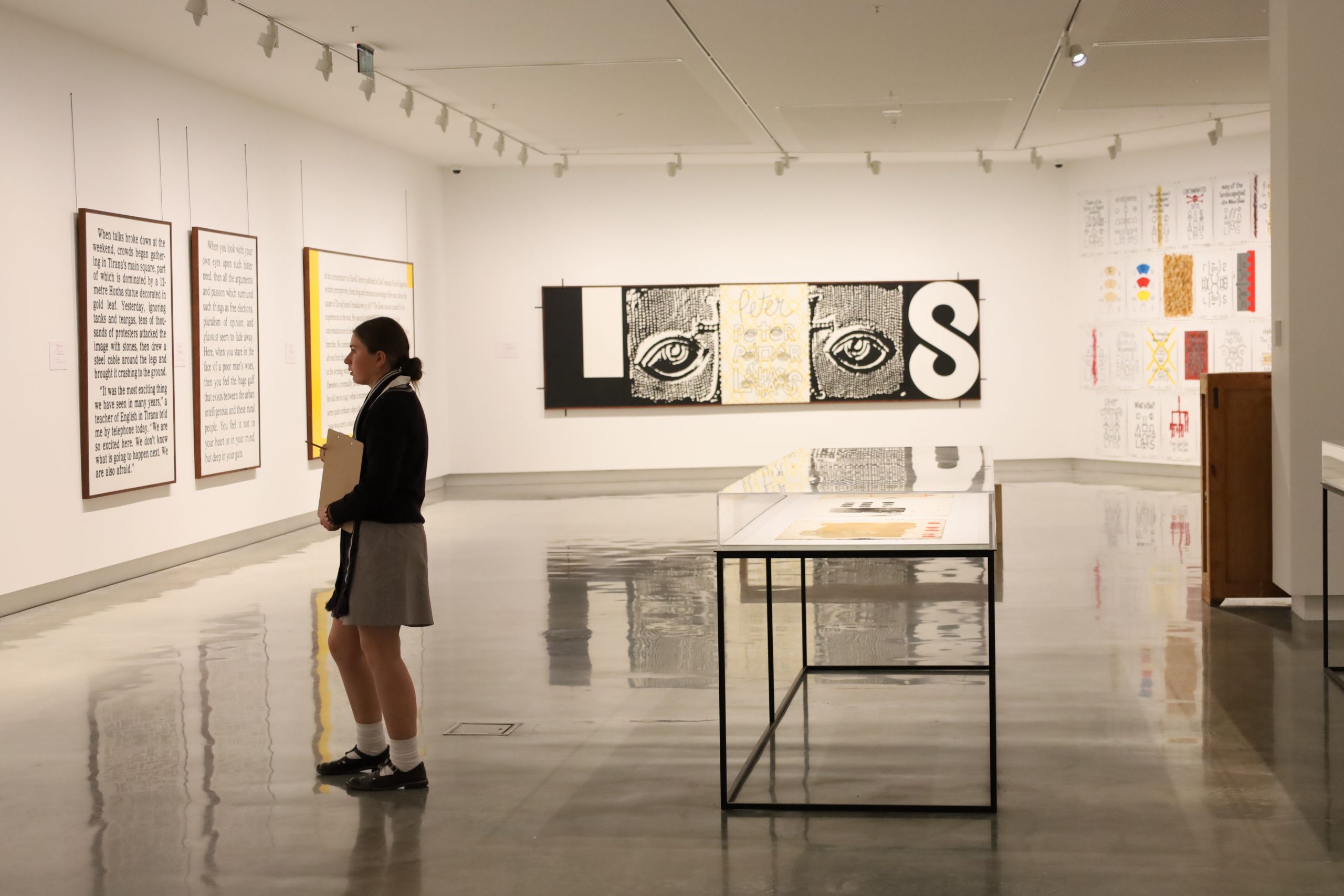 A female student looks at artwork in an empty gallery