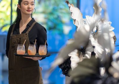 A young female waitress hold a tray with cocktails at a Buxton Event