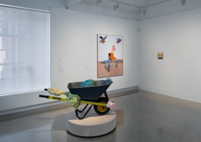 a sculpture of a wheelbarrow in a gallery