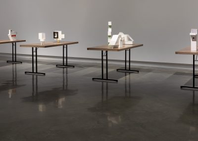 A series of small sculptures on four tables