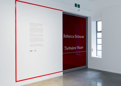 Gallery entrance with exhibition name and information on the wall