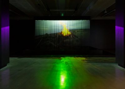A projection of a fire in a dark gallery