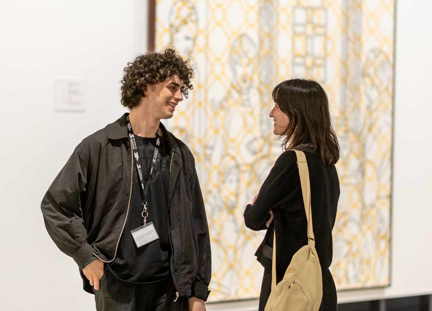 A student speaks to a visitor in the gallery